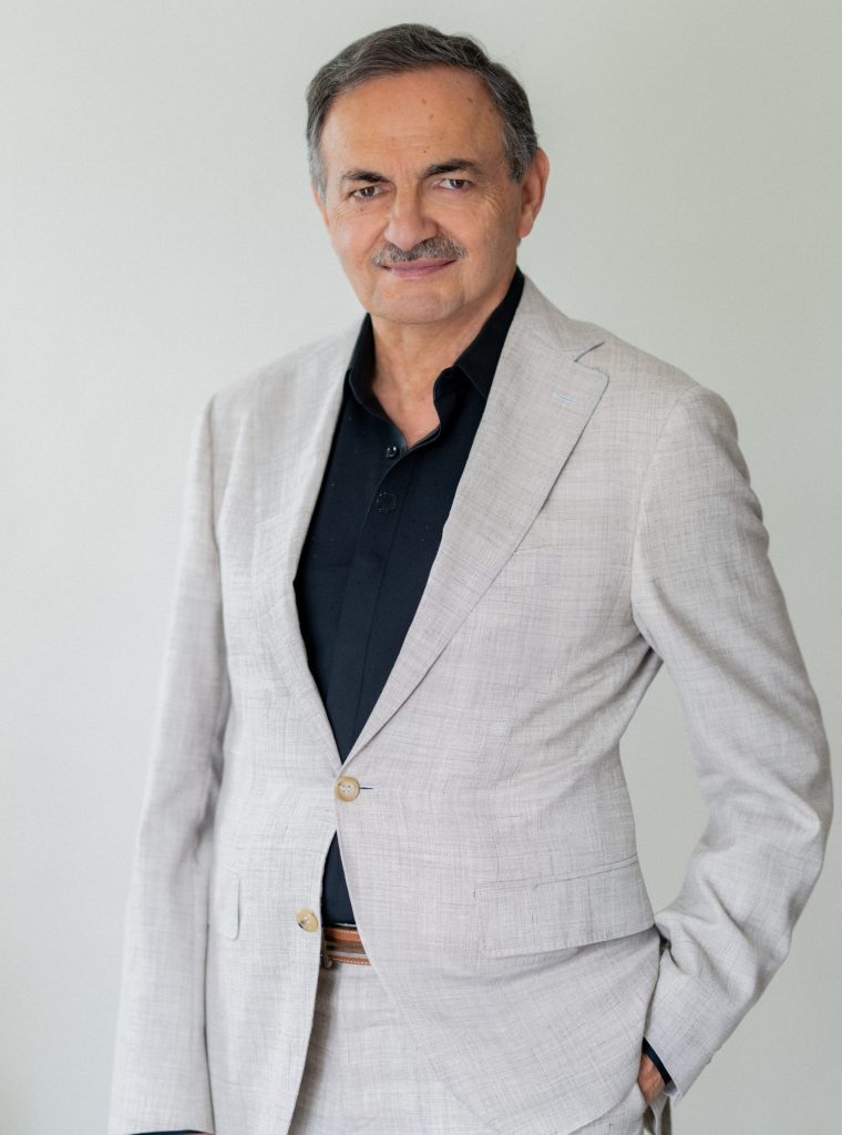 Commercial real estate professional in light gray suit studio portrait.