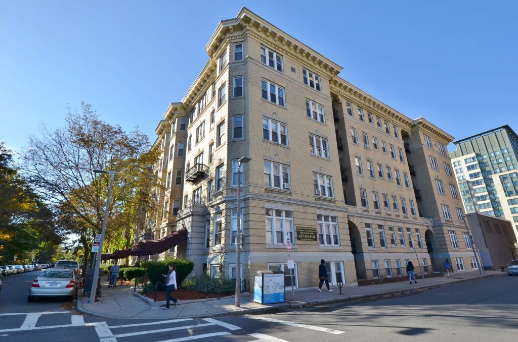 Historic urban apartment building on city street corner with classic architecture.