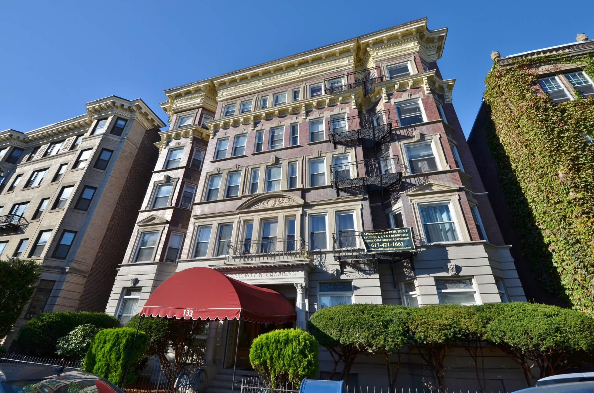 Mid-rise apartment building with decorative façades and a prominent entrance canopy, representing financing solutions for multifamily real estate investments.