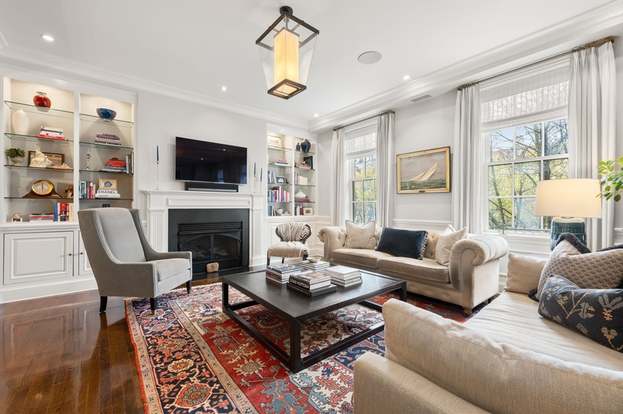 Upscale apartment living room with fireplace, custom built-ins, and abundant natural light, representing financing options for multifamily residential properties.