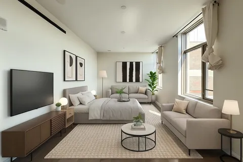 Bright open-plan apartment living room with large windows, modern furnishings, and a comfortable seating area.