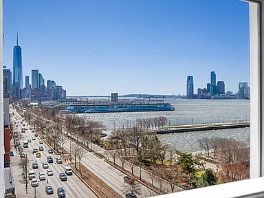 Panoramic view of a city skyline and waterfront, seen from a high-rise residential building overlooking a busy boulevard.