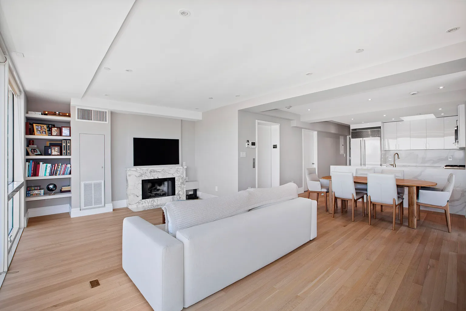 Bright open-concept living room with modern furnishings, hardwood floors, and a seamless connection to the dining area.