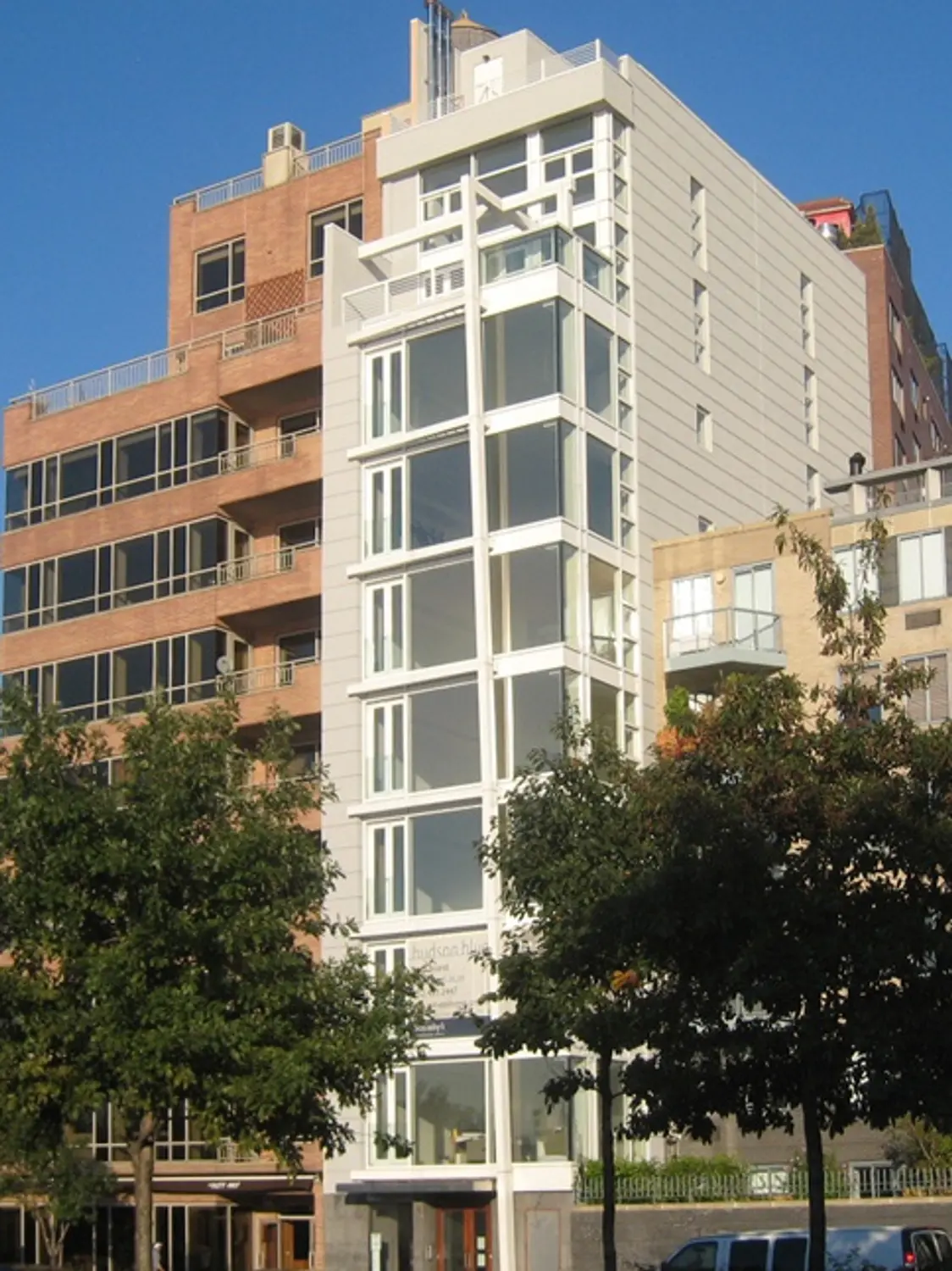 Modern mid-rise residential building with large windows, balconies, and a mix of contemporary architectural materials.