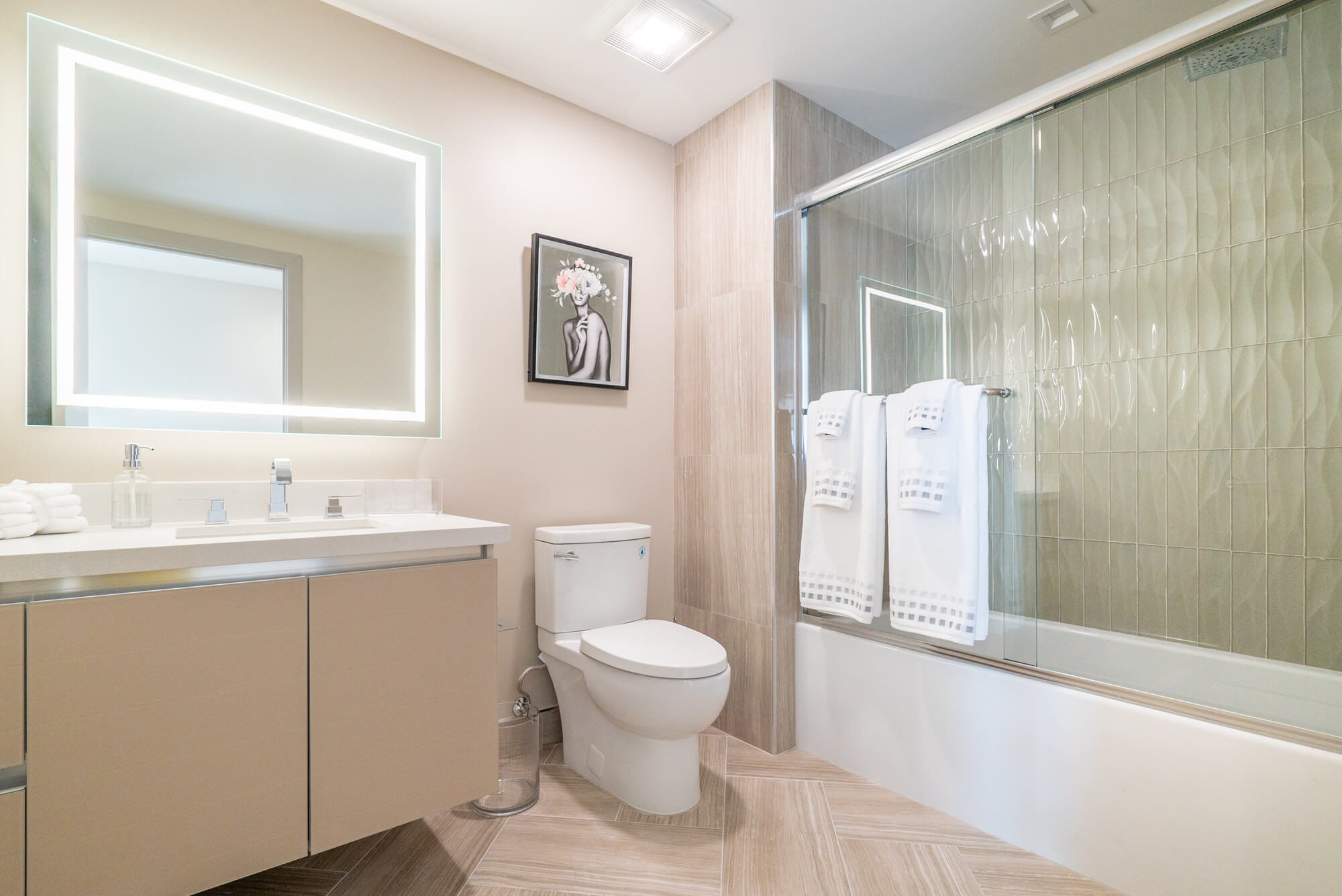 Contemporary bathroom featuring a glass-enclosed shower, vanity with illuminated mirror, and modern finishes.