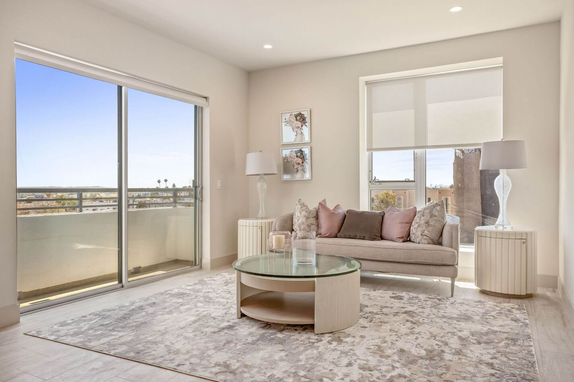 Sunlit apartment living room with large sliding glass doors, contemporary furnishings, and expansive views.