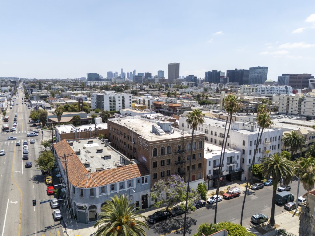Aerial view of multi-family residential neighborhood with urban city skyline in background.