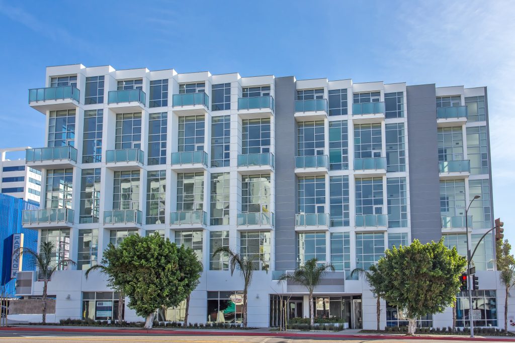 Modern multifamily residential building with balconies and contemporary architecture.