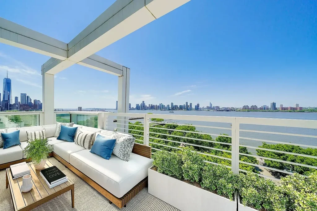 Luxury rooftop terrace lounge with outdoor seating and waterfront skyline views.