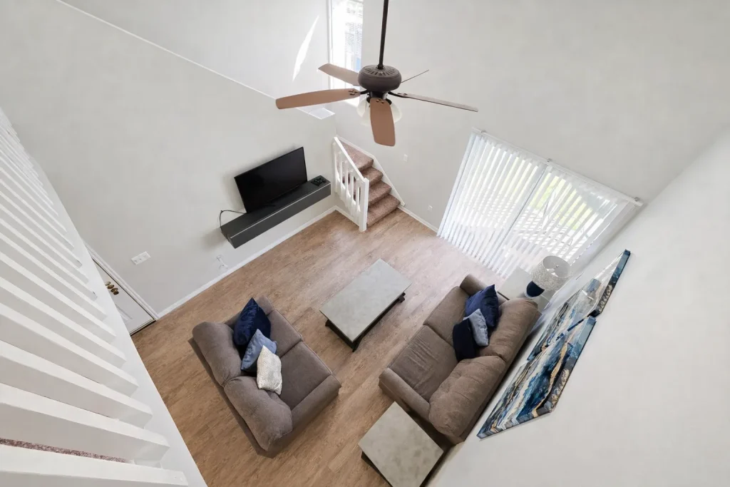 Bright luxury apartment interior with double-height ceiling and modern living room design.